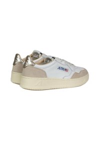 Zapatillas blancas con acentos de ante beige, tirador metálico en el talón, diseño con punt perforado en la punta y suela de goma crema. Presenta el logo "AUTRY" en el costado.