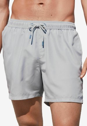 Graue Badeshorts aus leichtem Stoff, mit einem elastischen Bund und einem Kordelzug sowie einer glatten, matten Oberfläche.