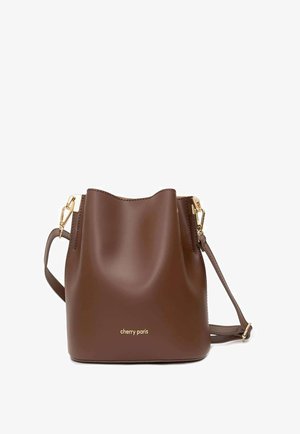 Sac seau en cuir marron avec ferrures dorées et bandoulière ajustable, marqué "cherry paris" au centre avant.