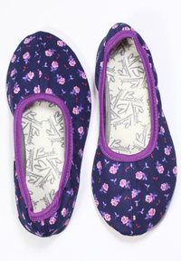 Blumen-Ballerinas aus marineblauem Stoff mit lila Akzenten. Sie verfügen über kleine rosa und lila Blumenmuster, eine runde Zehenpartie und ein slip-on Design.