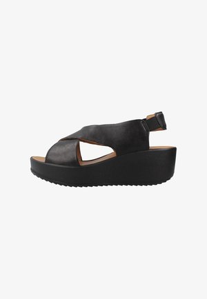 Zwarte leren wedge sandalen met een open teen-ontwerp, voorzien van uitsnijdingen en een verstelbare achterkantriem. Dikke zwarte gestructureerde zool.