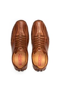 Braune Lederschuhe mit genähten Details, elastischen Bändern und einer strukturierten Sohle. Das Innere verfügt über eine markierte Einlegesohle.