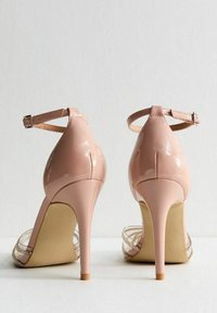 Nude lackläder högklackade skor med tunna ankelband, genomskinliga sidopaneler, utsmyckade med små silverdetaljer, spetsig tå och stilettklack.
