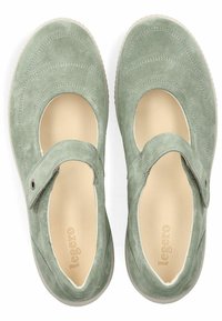Zapatos Mary Jane de ante verde con una correa ajustable, punta redonda, detalles laterales con corte y una plantilla beige, que presenta una superficie texturizada.
