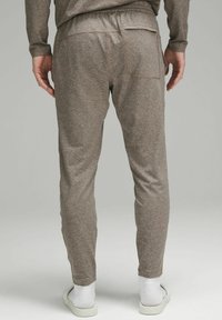 Ruskeat verkkohousut, joissa on slim fit -malli, elastinen vyötärö ja kaksi takataskua. Kangas on tekstuuroitu ja hieman joustava.