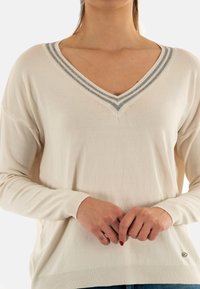 Maglione con scollo a V in avorio con colletto a righe blu. Caratterizzato da maniche lunghe, polsini a coste e dettaglio etichetta sull'orlo. Texture morbida, vestibilità comoda.