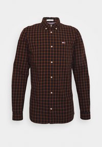 Langärmliges karierter Hemd mit schwarzem Grundton und orangefarbenen sowie gelben Linien, Knopfleiste vorne und einem kleinen eingestickten Logo auf der Brust.