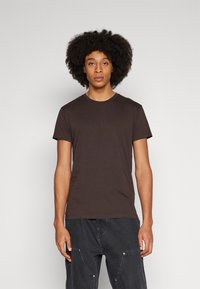 Brun kortermet t-skjorte laget av bomull med rund hals, med en jevn tekstur og en tettsittende design.