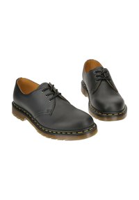 Scarpe in pelle nera con punta tondeggiante, design con lacci e cuciture gialle lungo la suola. Presentano una suola esterna in gomma durevole e testurizzata.