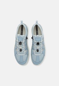 Zapatillas deportivas de color azul claro, con material de malla y sintético, que presentan un diseño de cordones, detalles en negro y suelas de goma para un mejor agarre.