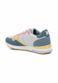 Zapatilla que presenta una combinación de colores pastel: azul verdoso, rosa, amarillo y gris. Texturas suaves y de malla con una suela acolchada y cordones blancos.