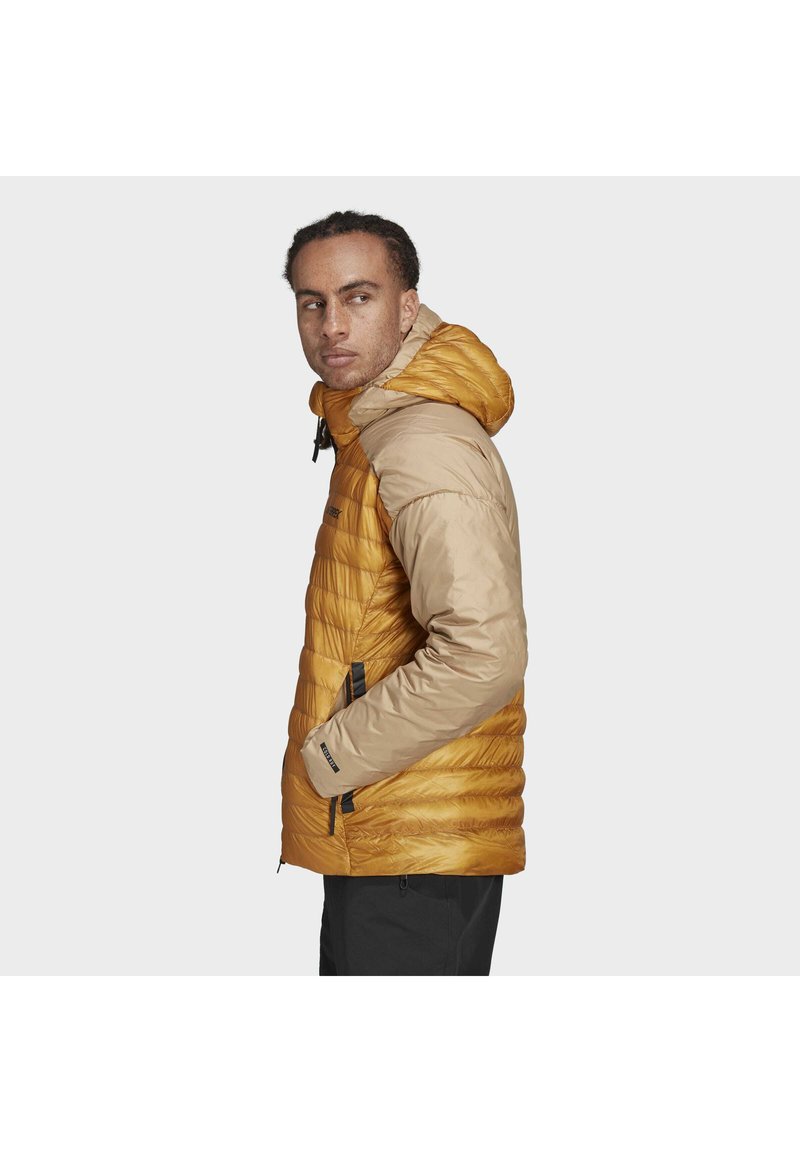 Aufblasbare Jacke mit Kapuze, in goldenem Gelb und hellbraunen Ärmeln. Strukturierte Außenschicht mit Reißverschlusstaschen und verstellbarem Saum.