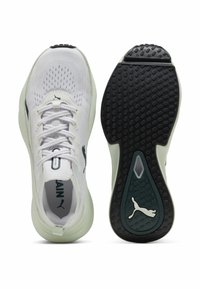 Scarpe sportive bianche con tomaia in mesh, accenti verdi, lacci e suole in gomma nera testurizzata. Presentano il logo sul lato e sul tallone.