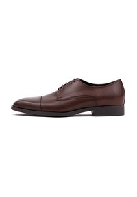 Brązowe skórzane buty eleganckie z wydłużonym noskiem, sześcioma otworami na sznurowadła, gładką cholewką i subtelnym przeszyciem, osadzone na niskiej czarnej gumowej podeszwie.
