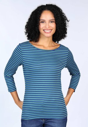 Blau-grün gestreiftes langärmliges Oberteil mit gerippter Textur und weitem Ausschnitt. Kombiniert mit Jeans.