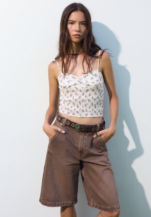 Blomsterprintet smocked crop top, let stof; brune denimshorts med sidelommer og et øje-bælte, der har en glat tekstur og afslappet pasform.