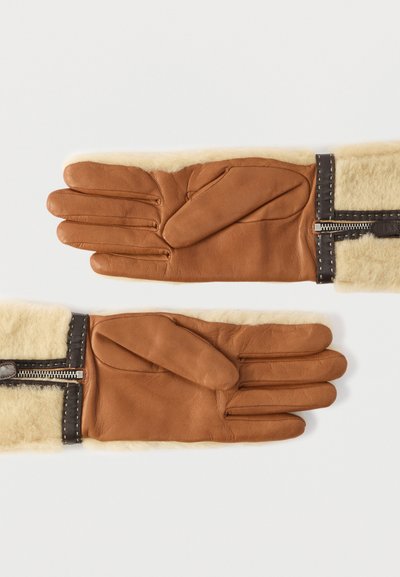 Καφέ δερμάτινα γάντια με κρέμ μανσέτα από shearling, με φερμουάρ και αντίθετες ραφές. Τα δάχτυλα και η παλάμη έχουν υφή.