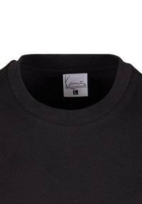 Black cotton t-shirt featuring a crew neckline and a label with the brand name. Smooth texture and simple, unadorned design.