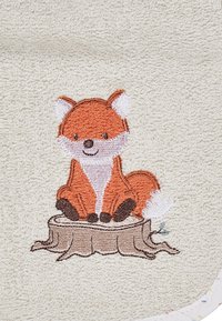 Handtuch mit einem gestickten orangefarbenen Fuchs mit weißen Akzenten, der auf einem braunen Baumstumpf sitzt, vor einem weichen, beigefarbenen strukturierten Hintergrund.
