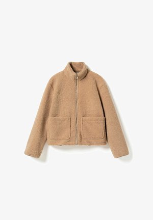 Beežist fliisist jakk kõrge kraega, täispika esiluku ja kahe esipidise taskuga. Omaduseks on pehme, tekstureeritud kangas ja lühendatud lõige.