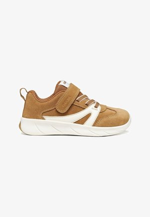 Sneaker in suede marrone con dettaglio laterale bianco, lacci elastici e una singola fascia in velcro su suola in gomma bianca.