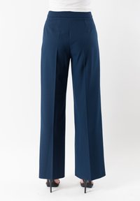Pantaloni a gamba larga blu navy con una texture liscia, caratterizzati da una vita alta, pieghe visibili e una linea pulita fino all'orlo.