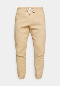 Beige joggingsbroeken van katoen, met een elastische tailleband met een trekkoord, taps toelopende pijpen en opgerolde zoom.