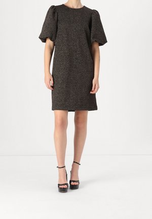 Robe marron texturée avec de courtes manches bouffantes et une coupe droite, associée à des talons compensés noirs. Encolure simple et design jusqu'aux genoux.
