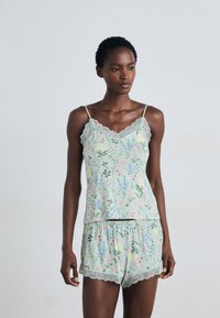 Lichtgroene cami en shorts set met kant, gekenmerkt door een bloemenpatroon in roze, geel en blauw op zachte stof.