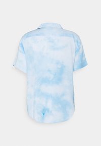 Camicia con maniche corte e bottoni, con un motivo tie-dye blu chiaro e bianco, mostrata dal retro su uno sfondo semplice.