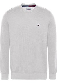 Ljusgrå stickad tröja med rund halsringning, långa ärmar, ribbade mudd och nederkant, samt en liten logotyp på bröstet.