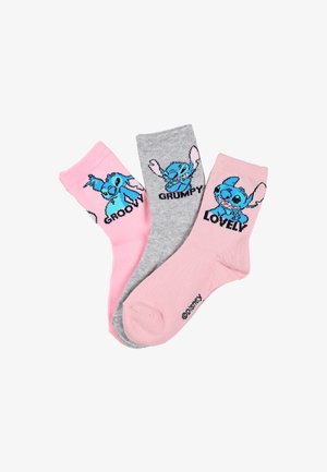 Tre paia di calzini alla caviglia: rosa con un personaggio dei cartoni animati blu etichettato "GROOVY", grigio con "GRUMPY" e rosa con "LOVELY". Texture a maglia.