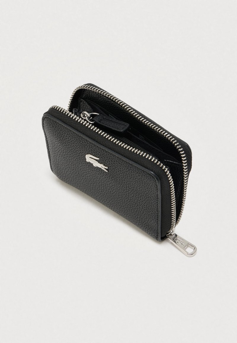 Sort tekstureret læderpung med sølvlynlås og krokodillelogo, delvist åben, der viser indvendige rum.