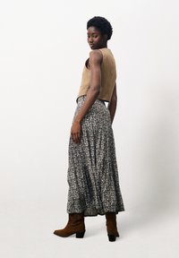 Bordeaux cropped top, grijs maxi-jurk met bloemenpatroon, bruine suède enkelboots en een textiele stof, gezien vanaf de zijkant en achterkant.