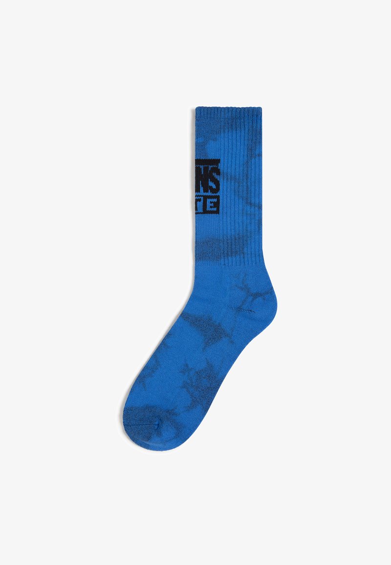 Chaussette en coton bleue au design en côtes, avec un motif abstrait bleu plus foncé et un logo noir imprimé sur le côté.