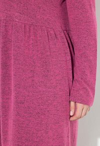 Jurk met lange mouwen in een gemêleerde roze stof, uitgevoerd met een geplooide taille en een ontspannen pasvorm met gestructureerde brei en zichtbare naden.