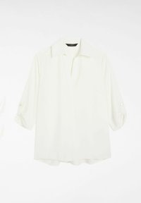 Blouse blanche à col avec un décolleté en V, manches trois-quarts retroussées, avec des boutons aux poignets. Tissu lisse et léger, ourlet droit.