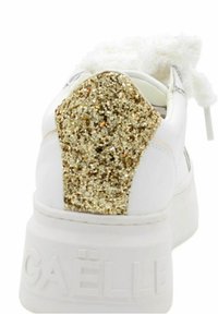 Sneaker bianca con un accento di tacco glitter dorato testurizzato, dettagli in morbida pelliccia bianca e una suola bianca spessa impressa con il nome del marchio.