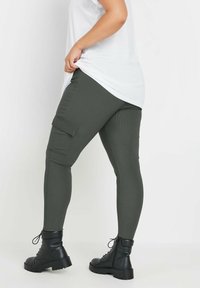 Cargo leggings i olivgrön, med en texturerad yta, sidofickor och matchade med svarta snörda kängor.