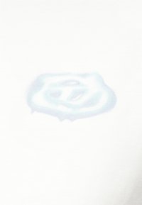 Σβησμένο μπλε και λευκό έμβλημα ασπίδας με ένα στυλιζαρισμένο γράμμα "S" σε λευκό ύφασμα.