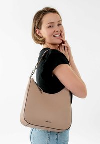 Beige leather handbag with a smooth, curved shape. Features a black edging and a silver chain strap. Simple design, no patterns or logos visible.