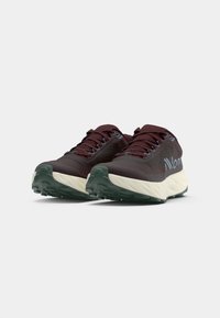 Maroon running shoes with textured mesh upper, contrasting cream midsole, and green rubber outsole featuring multi-directional treads.