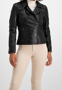 Černá kožená bunda s přiléhavým střihem, diagonálním zipem, dvěma předními zipovými kapsami a klopovým límcem. Hladká textura.