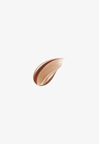 Échantillon lisse et courbé de fond de teint beige moyen avec une texture brillante sur un fond blanc uni.