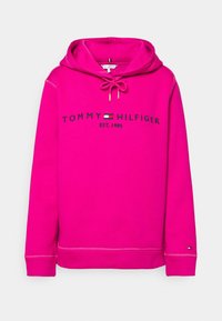 Růžová mikina s kapucí na šňůrku, s černým potiskem "TOMMY HILFIGER" a "EST. 1985". Žebrované manžety a spodní lem, měkká tkanina.