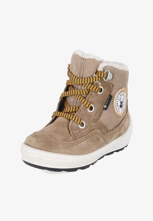 Beiger Veloursleder-Winterstiefel mit weißem Fellfutter, gelb-schwarzen Schnürsenkeln, robuster Sohle und rundem Aufnäher mit Hirsch-Logo an der Seite.