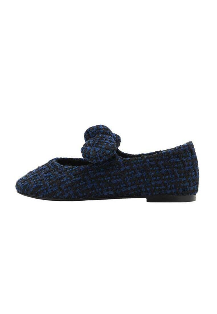 Scarpa piatta in tessuto intrecciato blu e nero con punta arrotondata, caratterizzata da un accento floreale sulla parte anteriore e un tacco basso di colore nero solido.