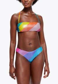 Bikini-set met een bandeau-top en lage broekjes. Gemaakt van glanzende stof met een multicolor diagonale streepjespatroon in levendige kleuren.