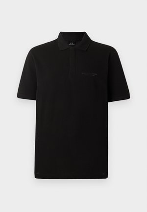 Crna pamučna polo majica kratkih rukava, s tri dugmeta na izrezu i diskretnim izvezenim logom na lijevoj strani prsnog koša. Glatka tekstura.