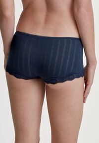 Marineblauwe hipster slipjes met verticale strepen, kantafwerking langs de benen, zachte stof en een elastische tailleband voor comfort.